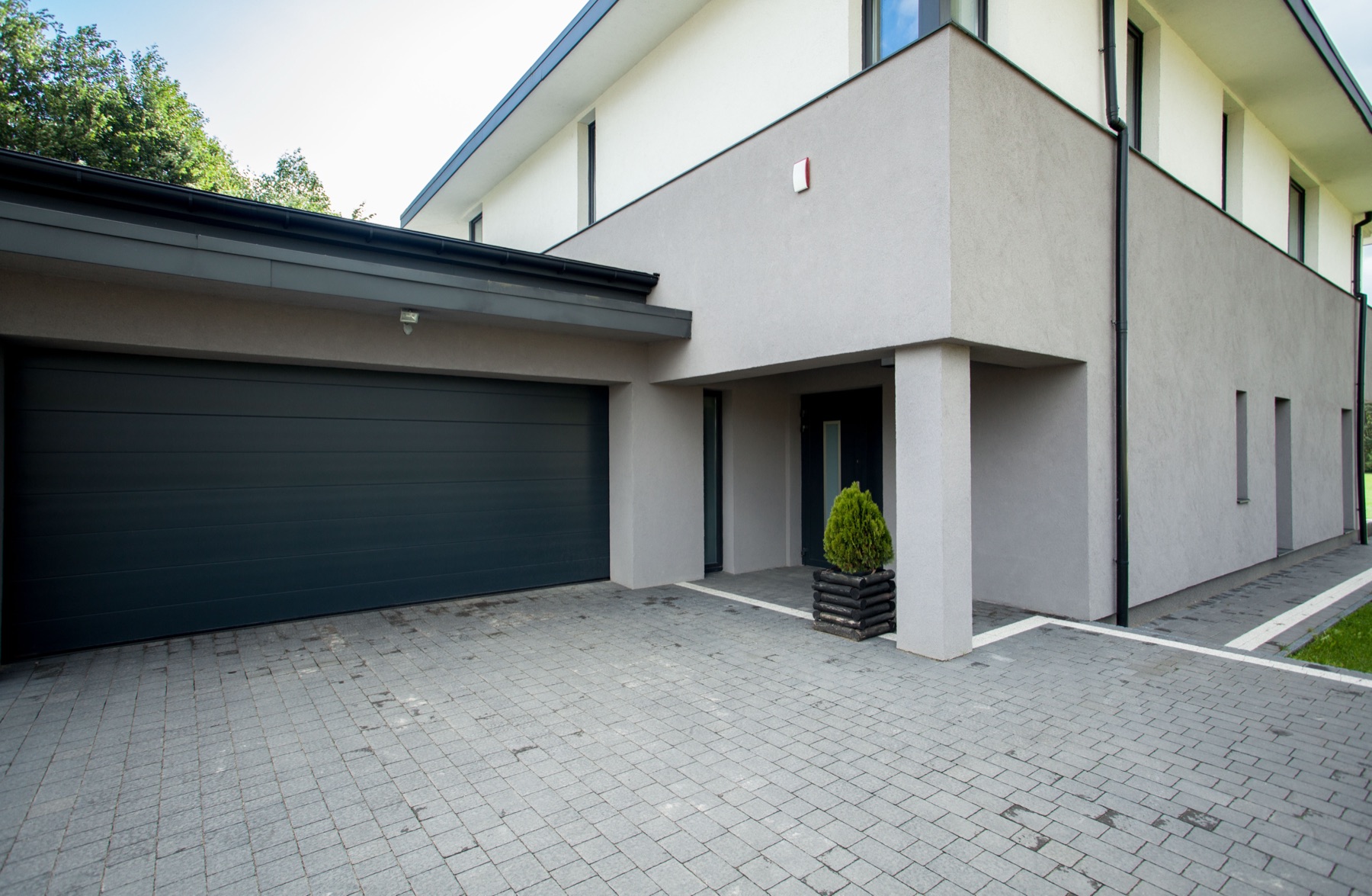 A residential garage door opening with an electronic remote control in the foreground
