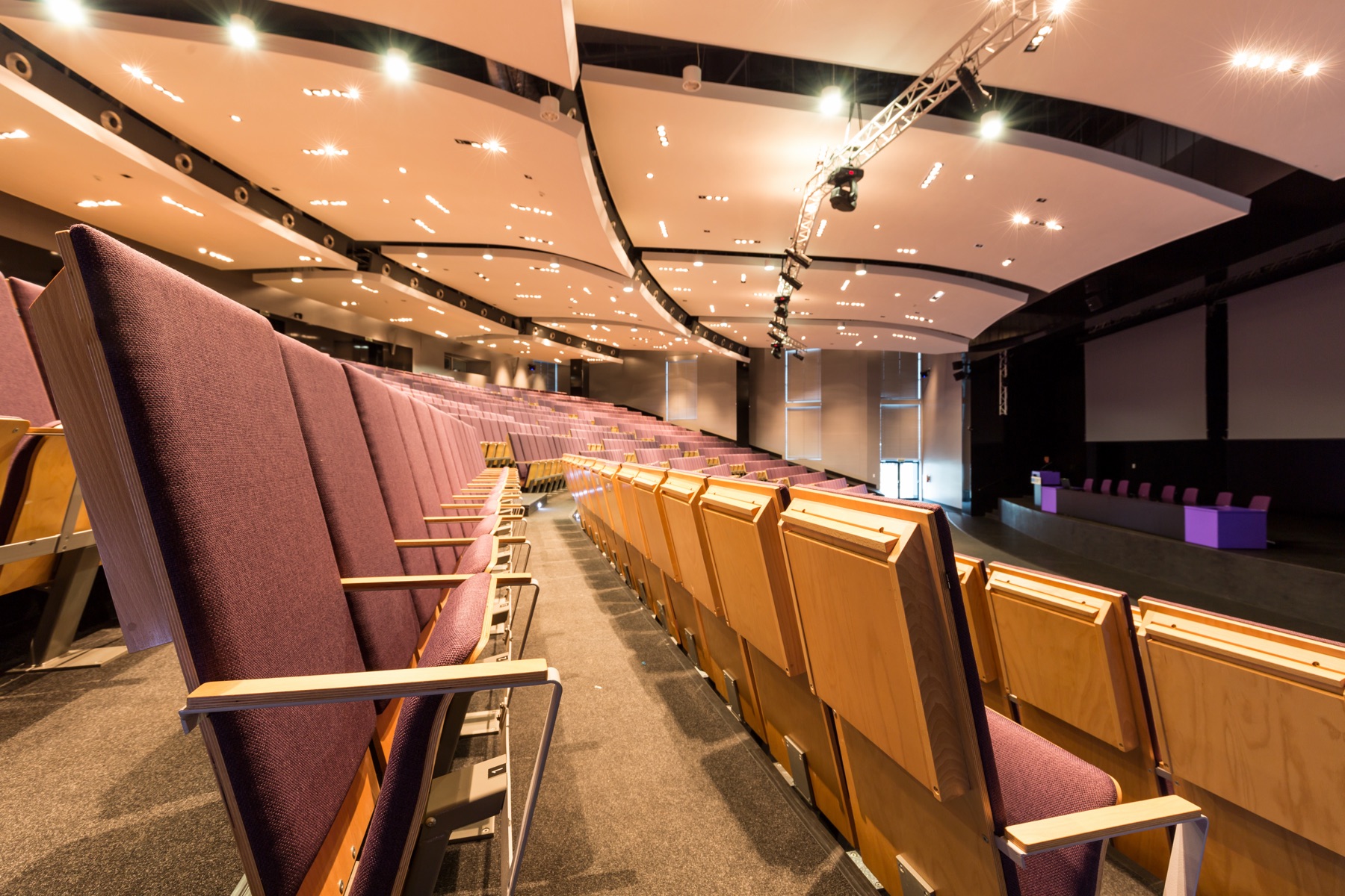 A vintage theater stage with an empty proscenium and rows of seats in soft light