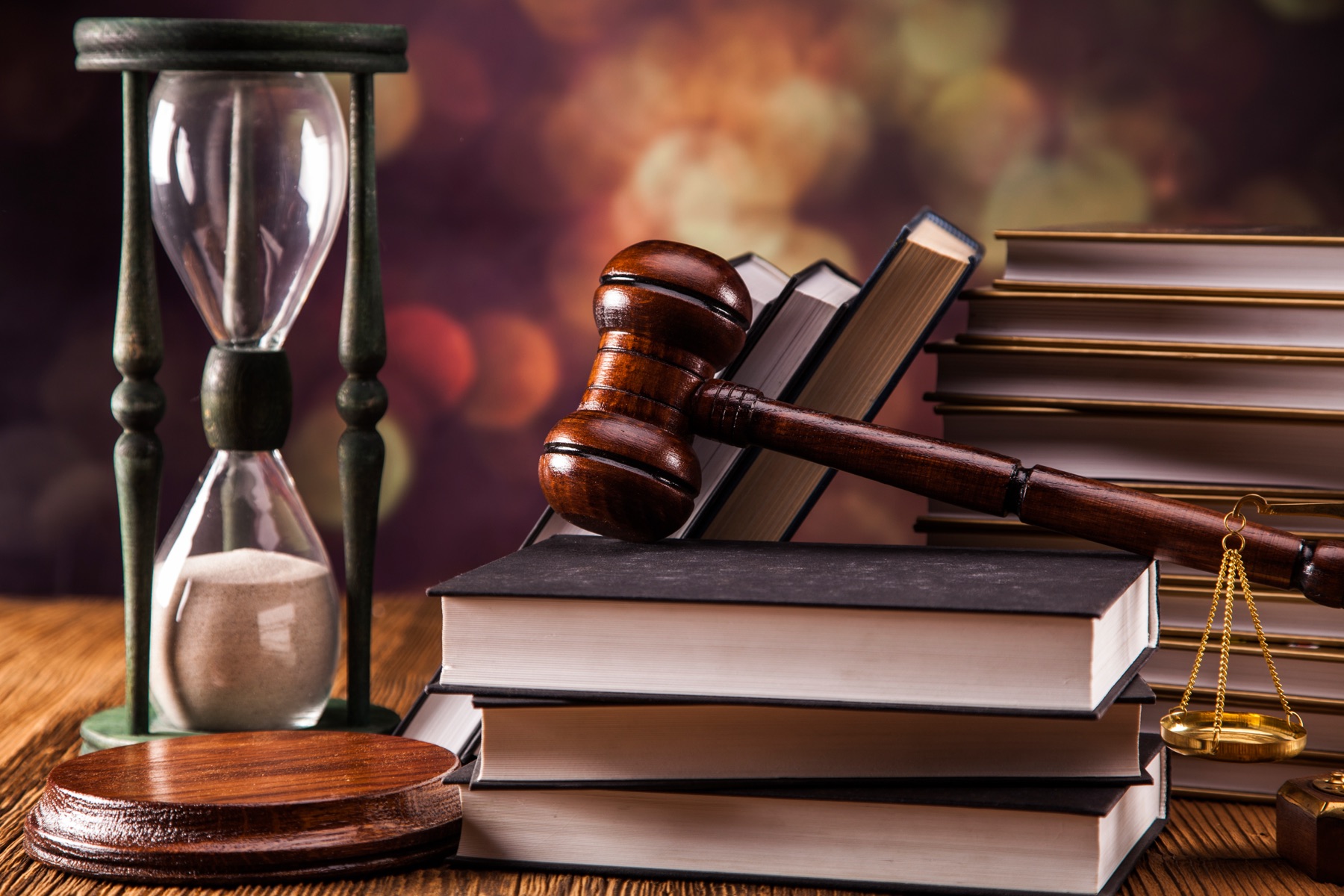 Bound legal volumes on a shelf beside a wooden gavel.