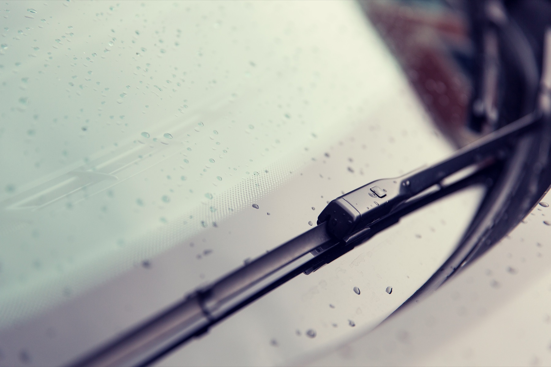 Windshield wiper blades on a car windshield in the rain