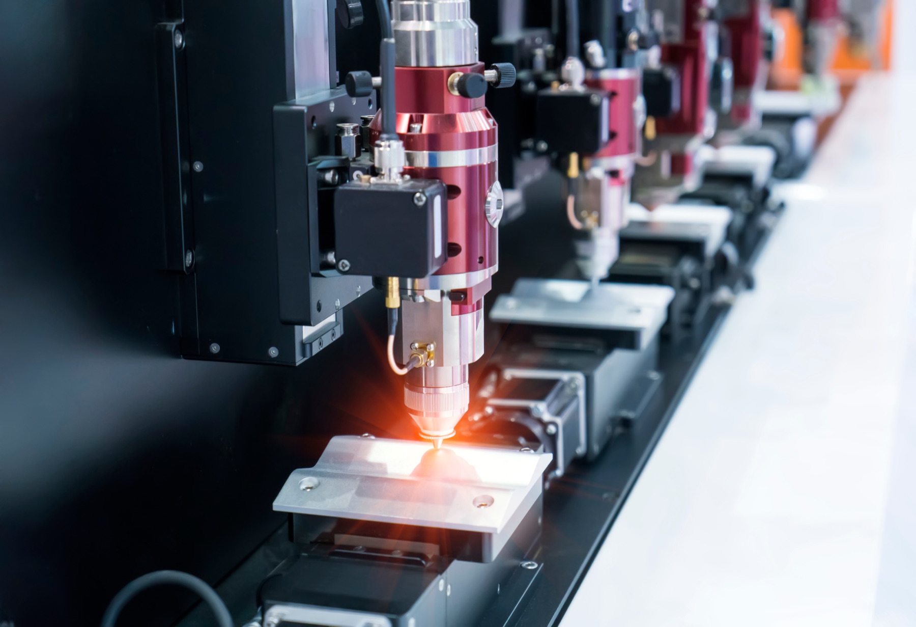 A laser projector casting alignment lines across an industrial work surface