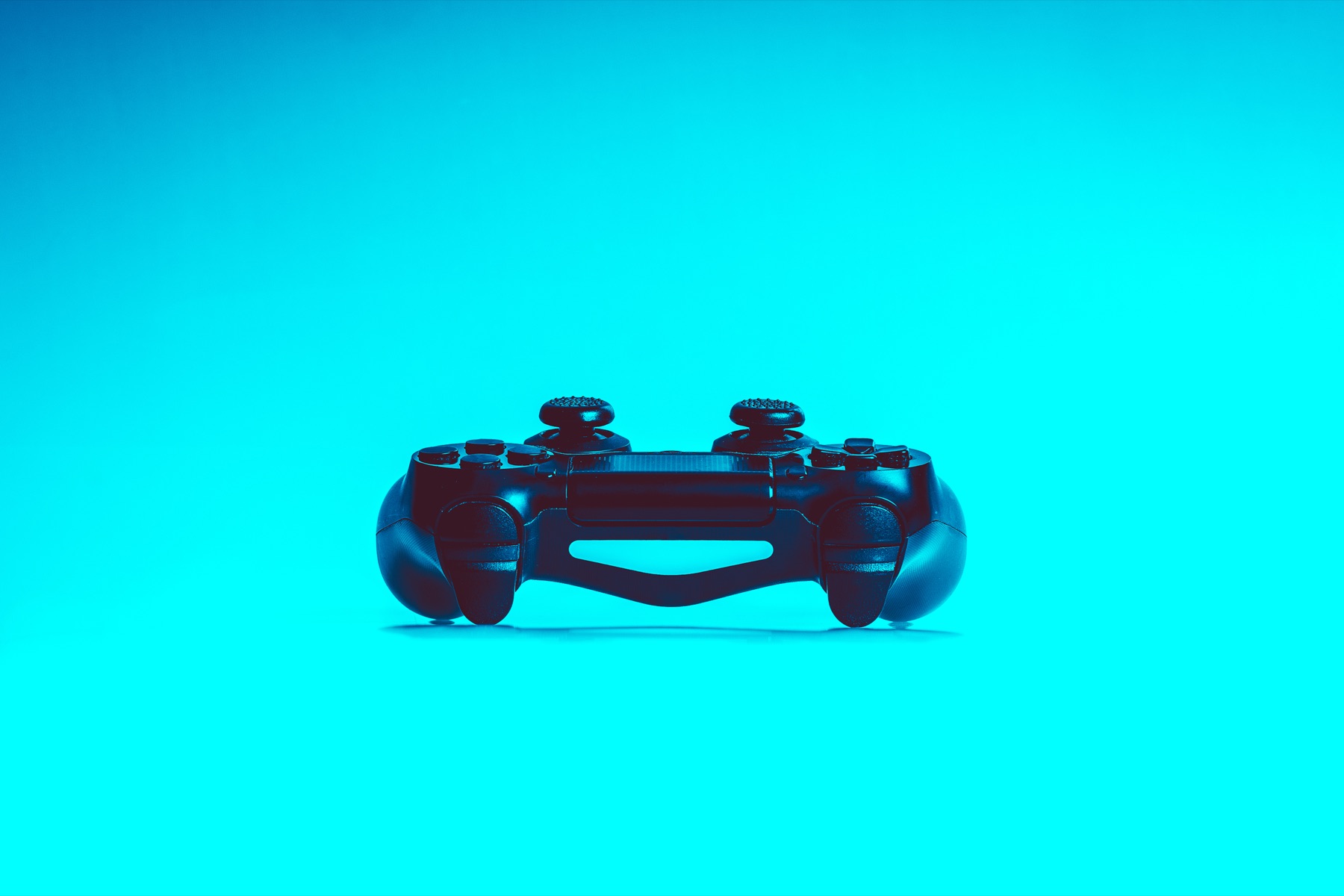 Game controller resting on a dark desk beside a keyboard