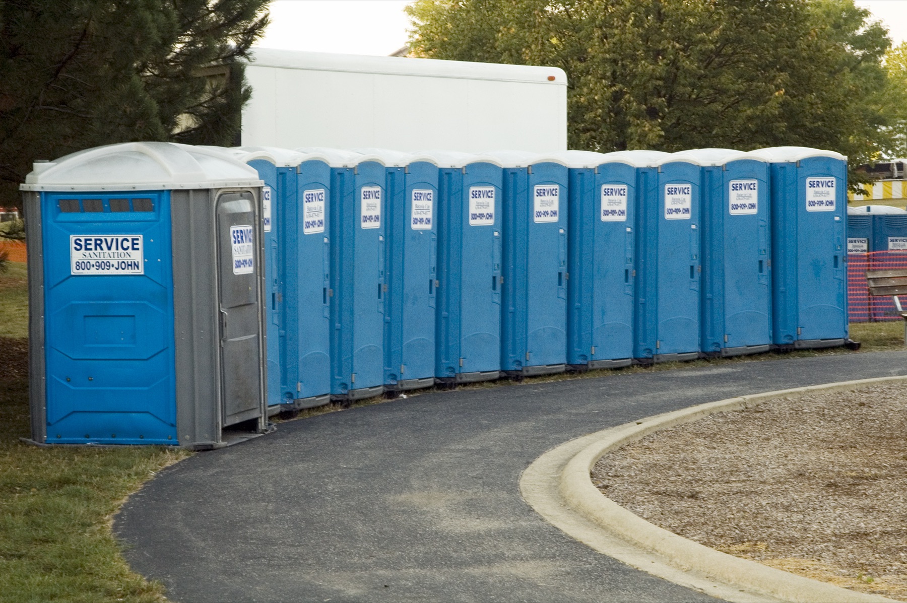 A row of portable toilets at an outdoor event