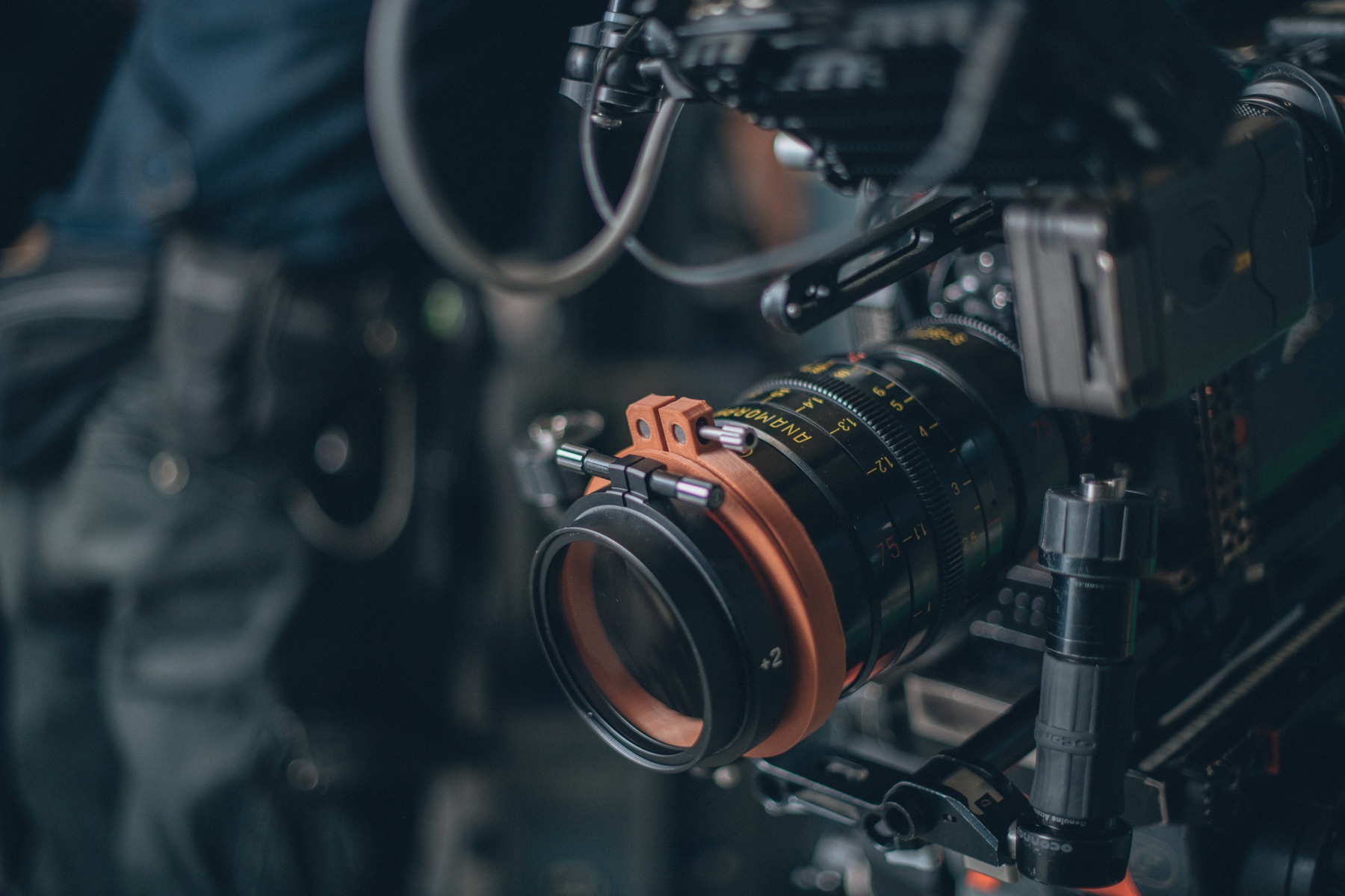 Film set with a camera crew shooting an outdoor scene at dusk