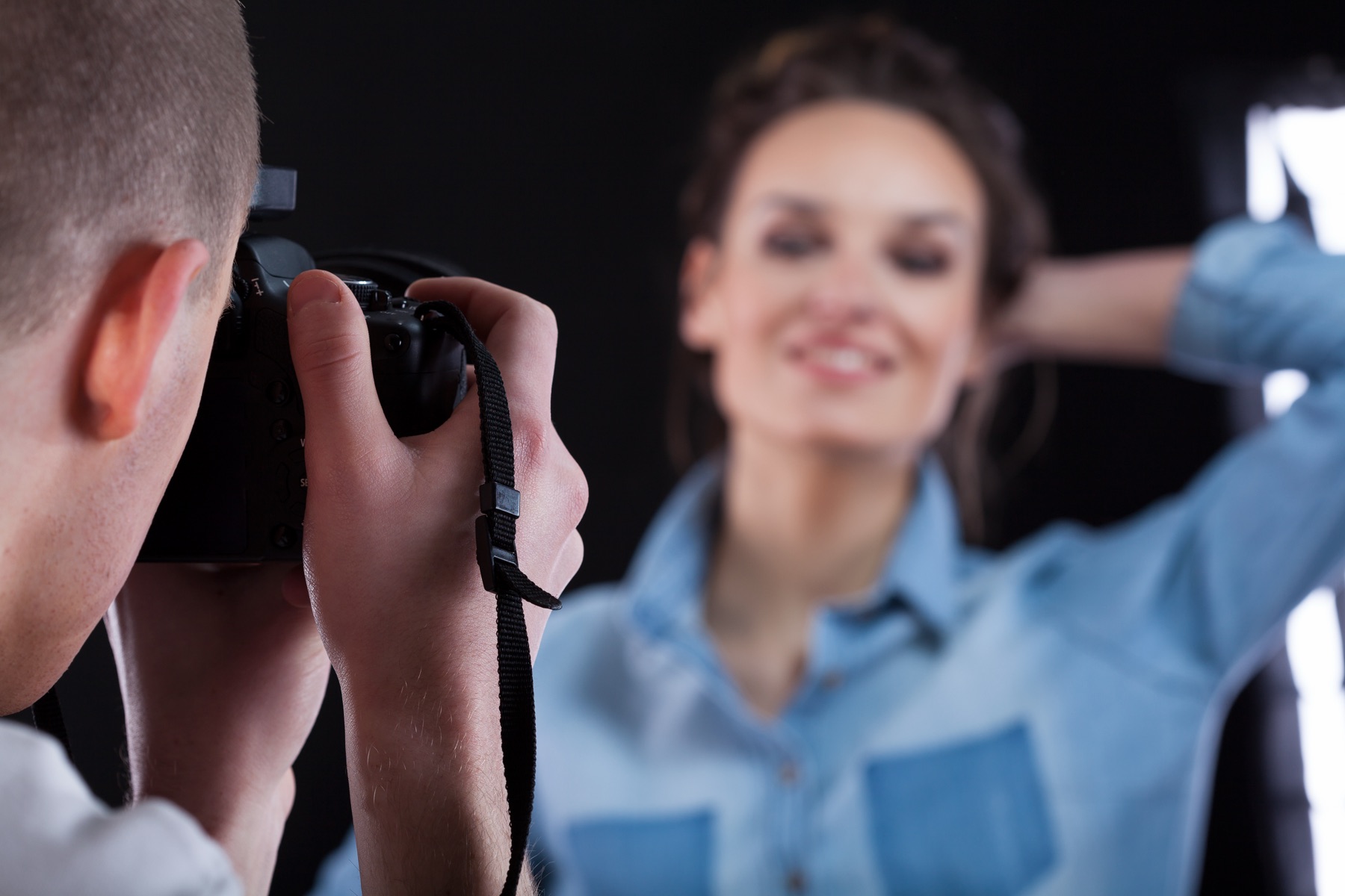 Photographer holding a camera in a studio during a model shoot
