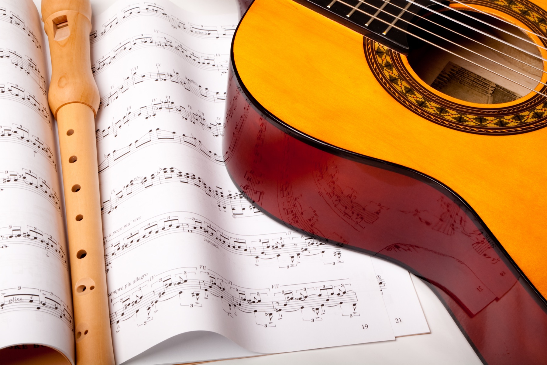 An acoustic guitar resting on sheet music