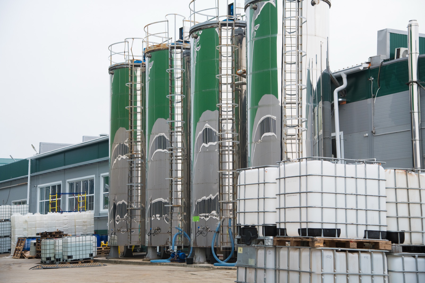 An industrial chemical plant with white pigment storage tanks and piping