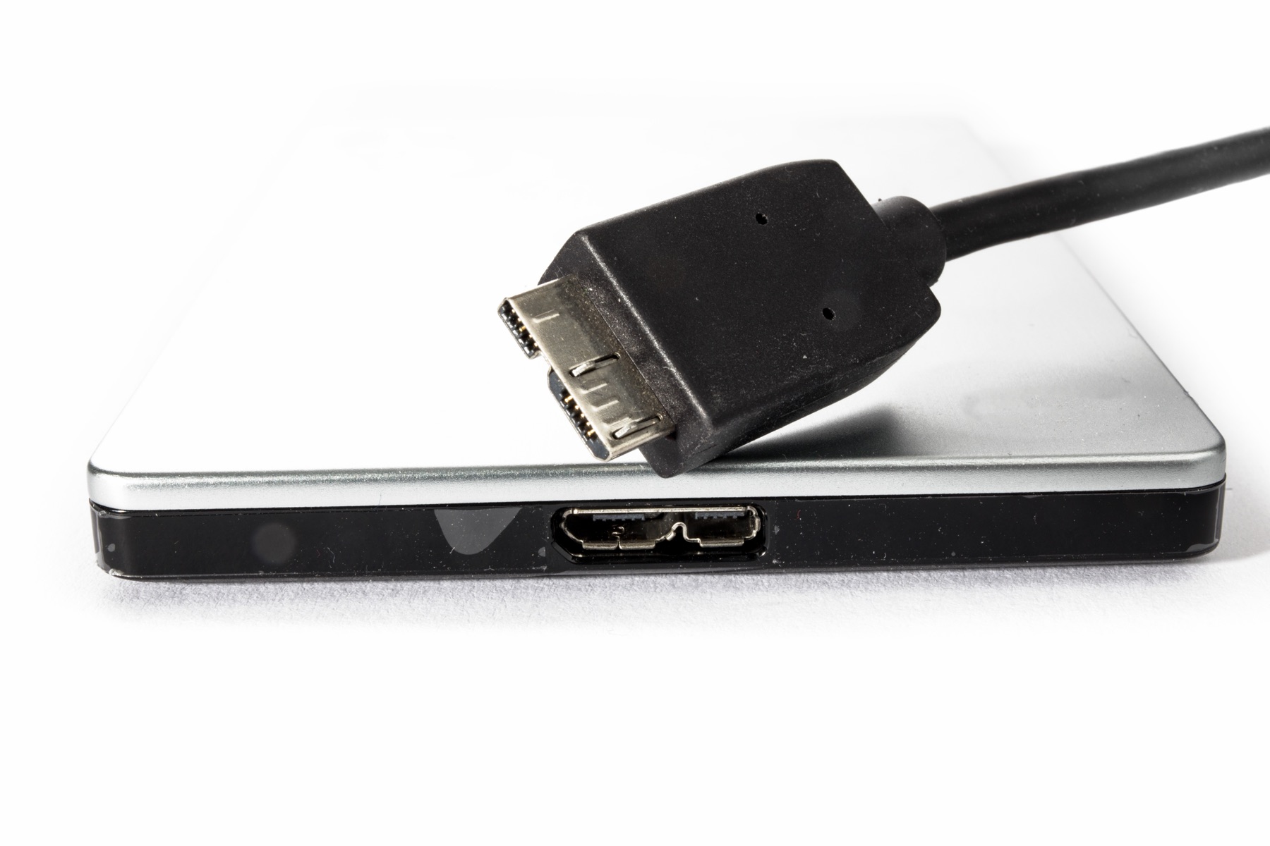 An external hard drive connected to a laptop in a darkened office