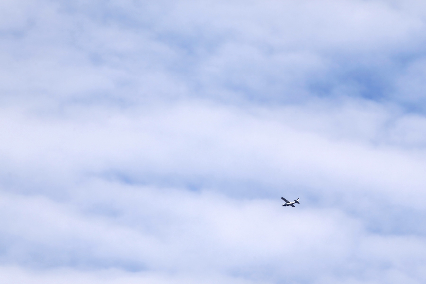 A small aircraft flying low over an industrial chemical plant
