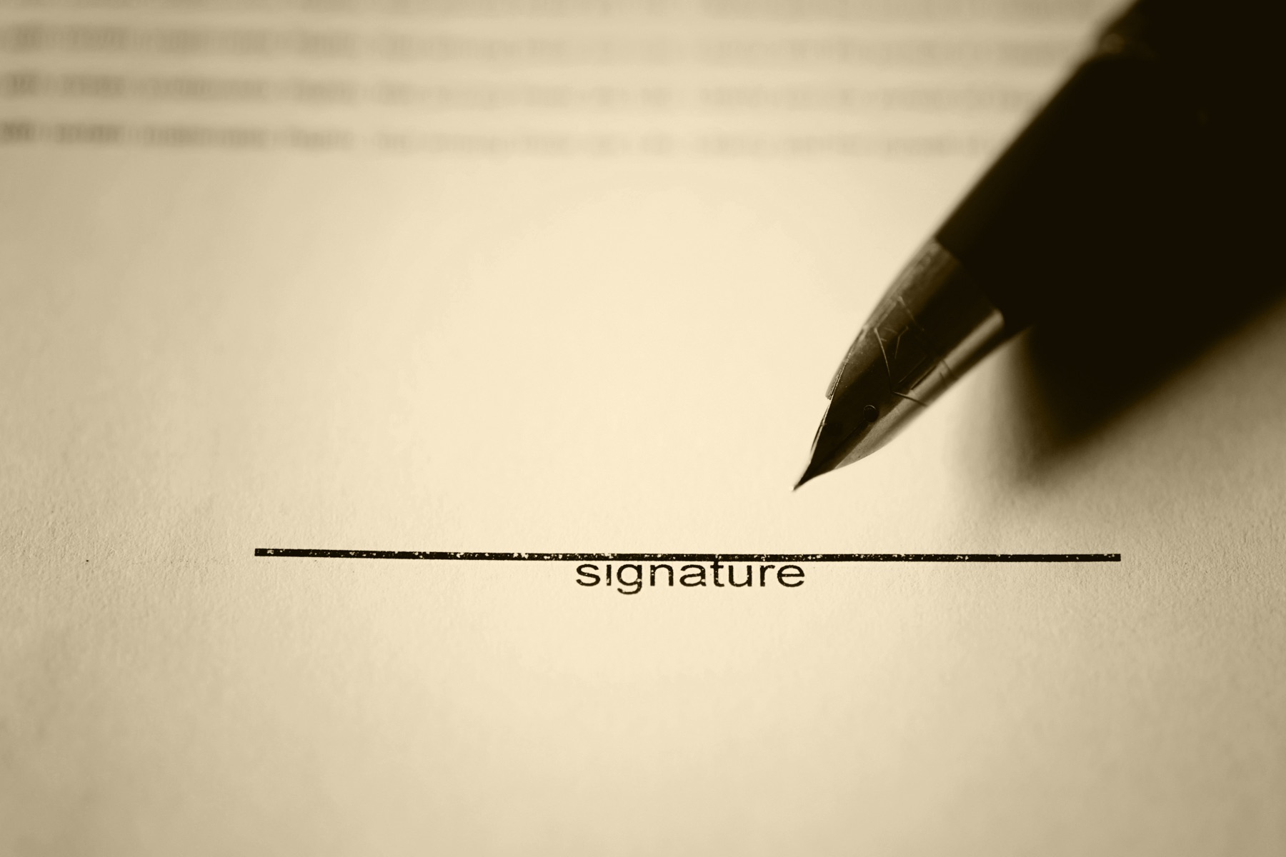 A person signing a confidentiality agreement at a desk