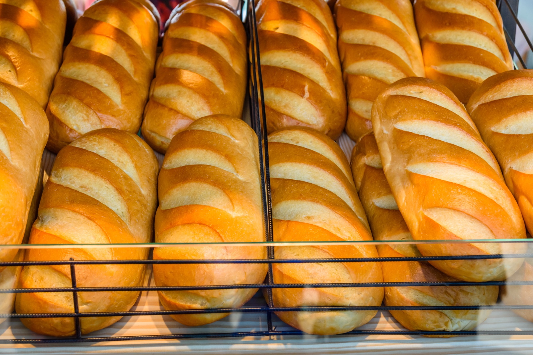 Bakery storefront display of doughnuts behind glass