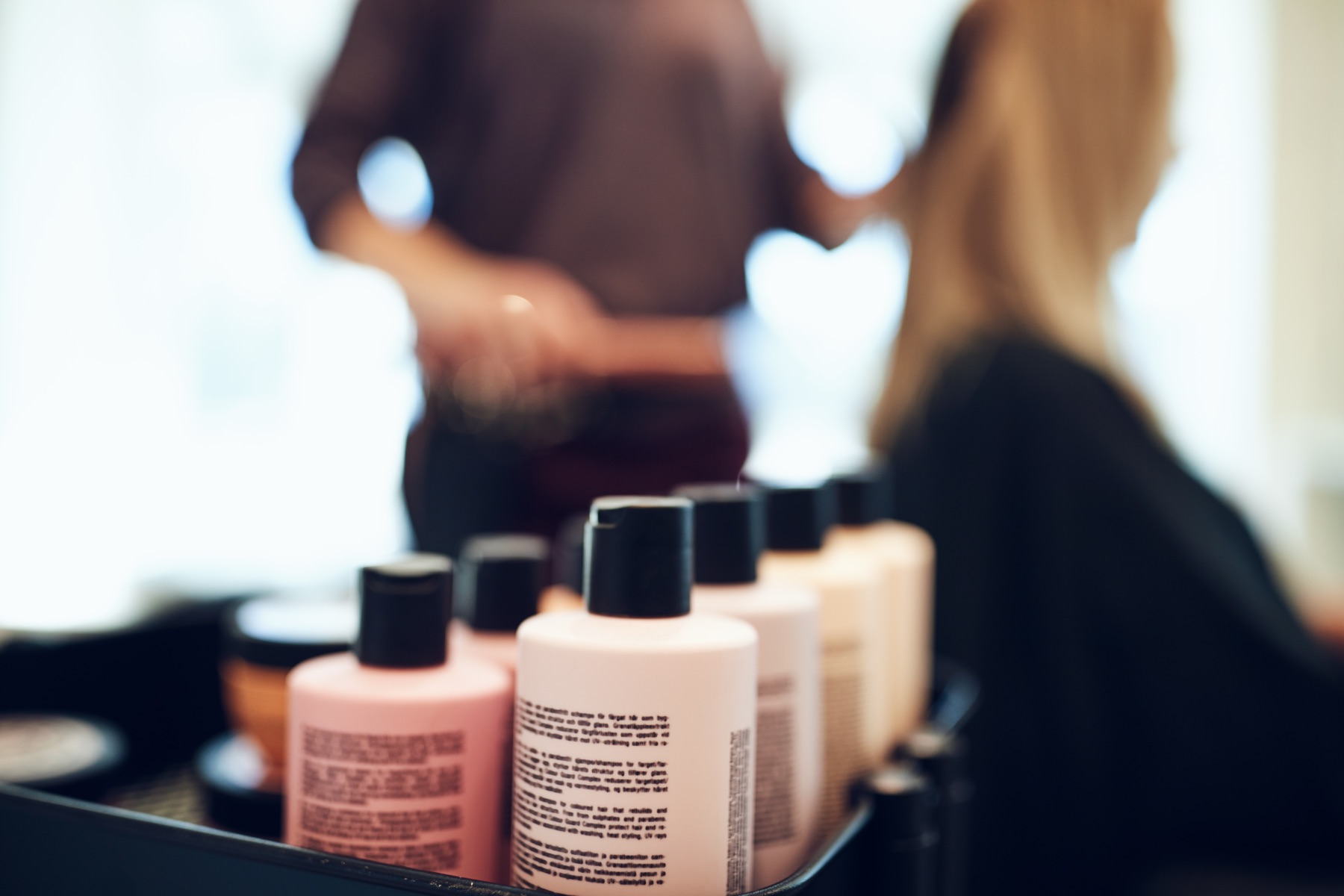 Row of hair-care and shampoo bottles on a salon shelf