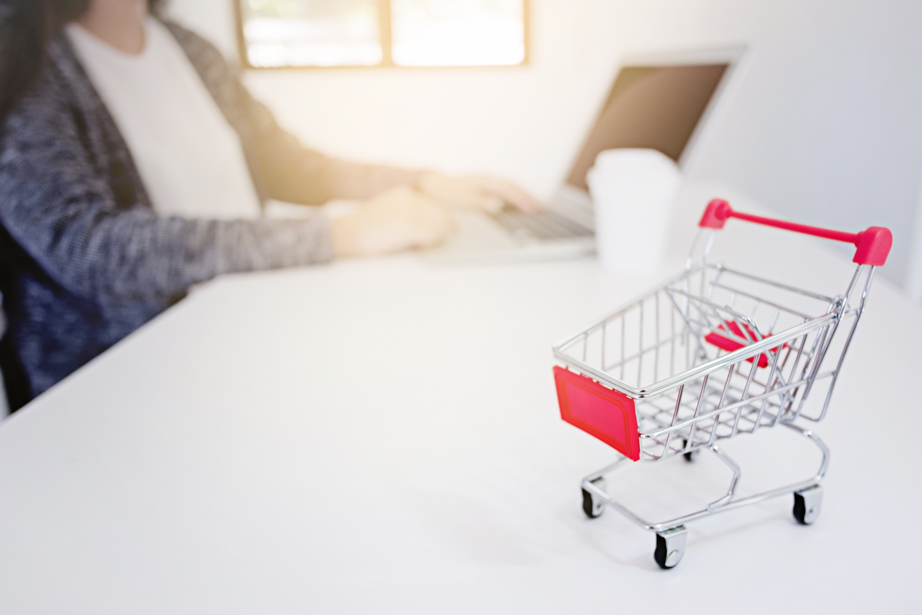 Person shopping on an online marketplace using a laptop and smartphone