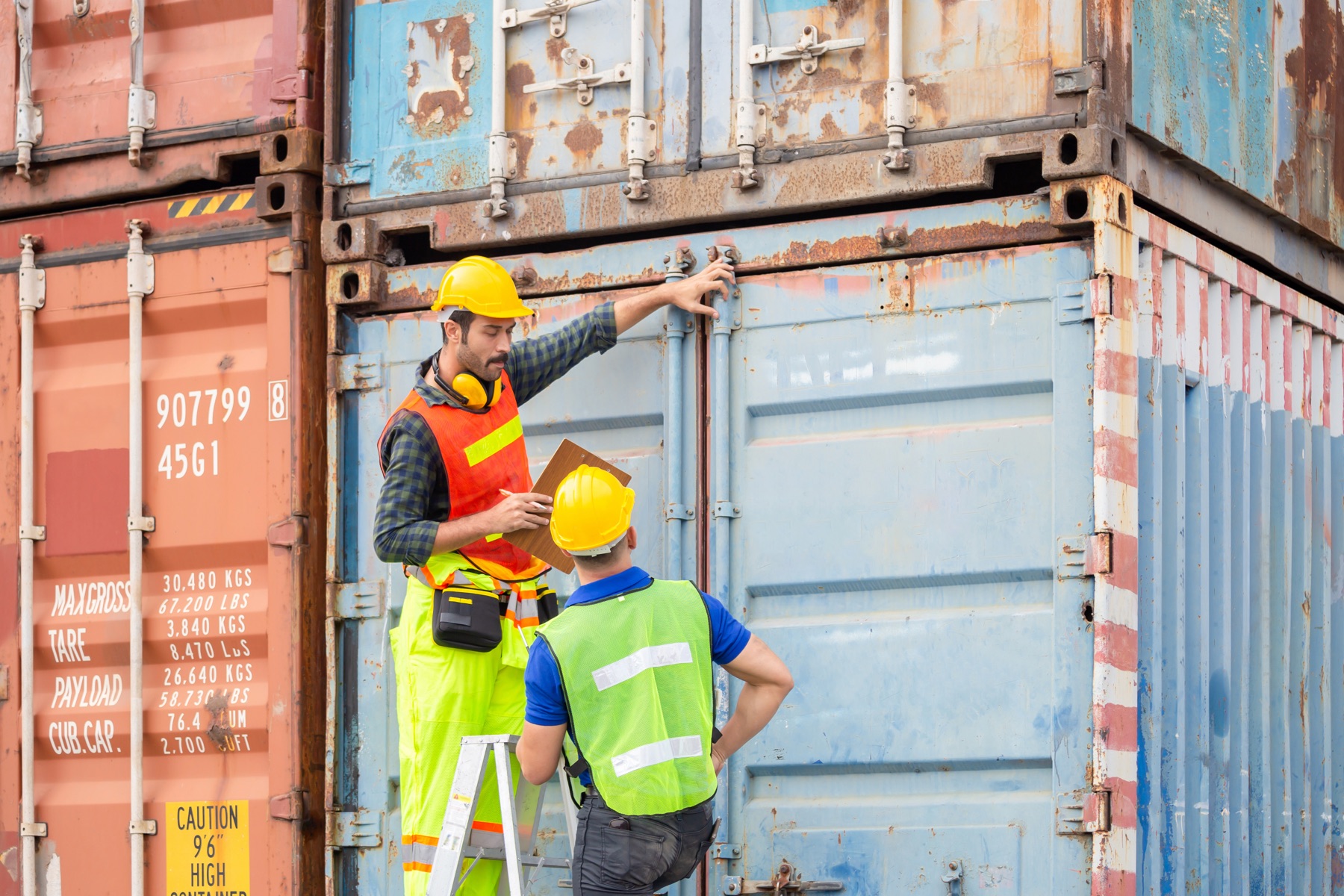 Cargo containers stacked at a port with a customs inspection area