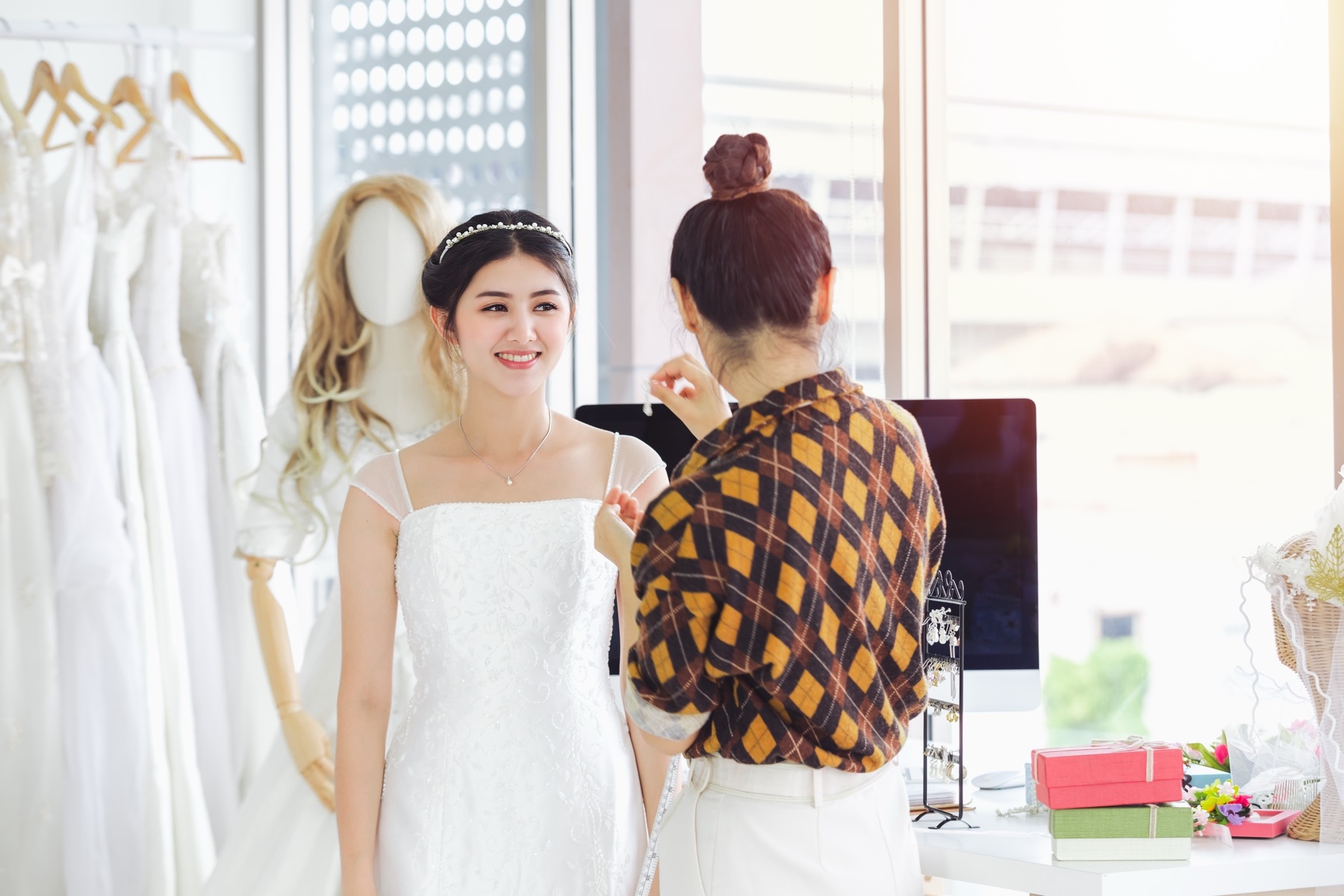 Wedding gowns displayed on mannequins in a bridal boutique window