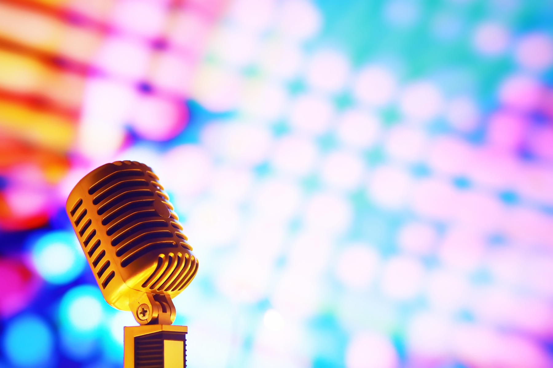 A vintage microphone on an empty concert stage under spotlights