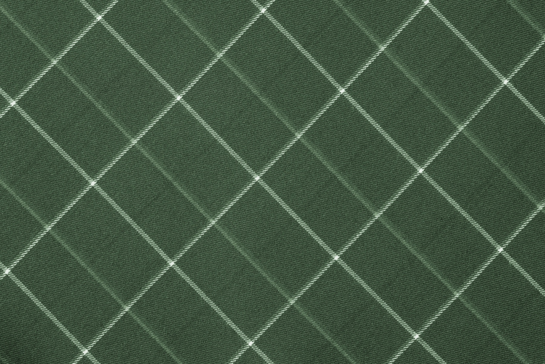 A close-up of a green-gold colored fabric pad against a neutral background